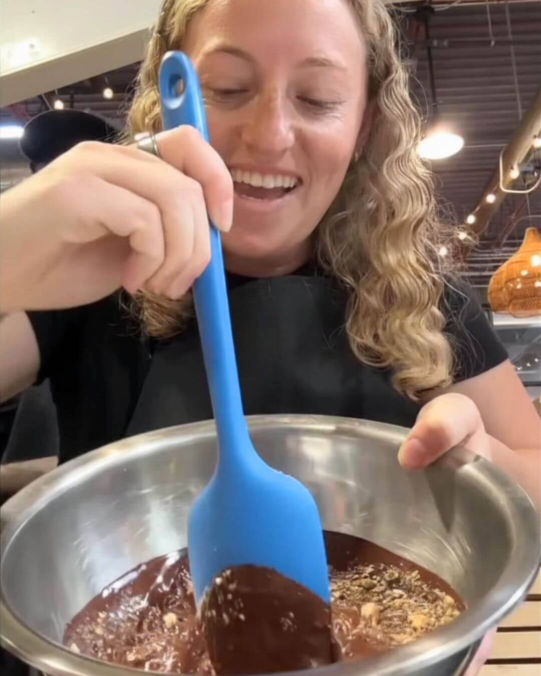 A participant mixes chocolate during Bibamba's bean-to-bar chocolate making experience