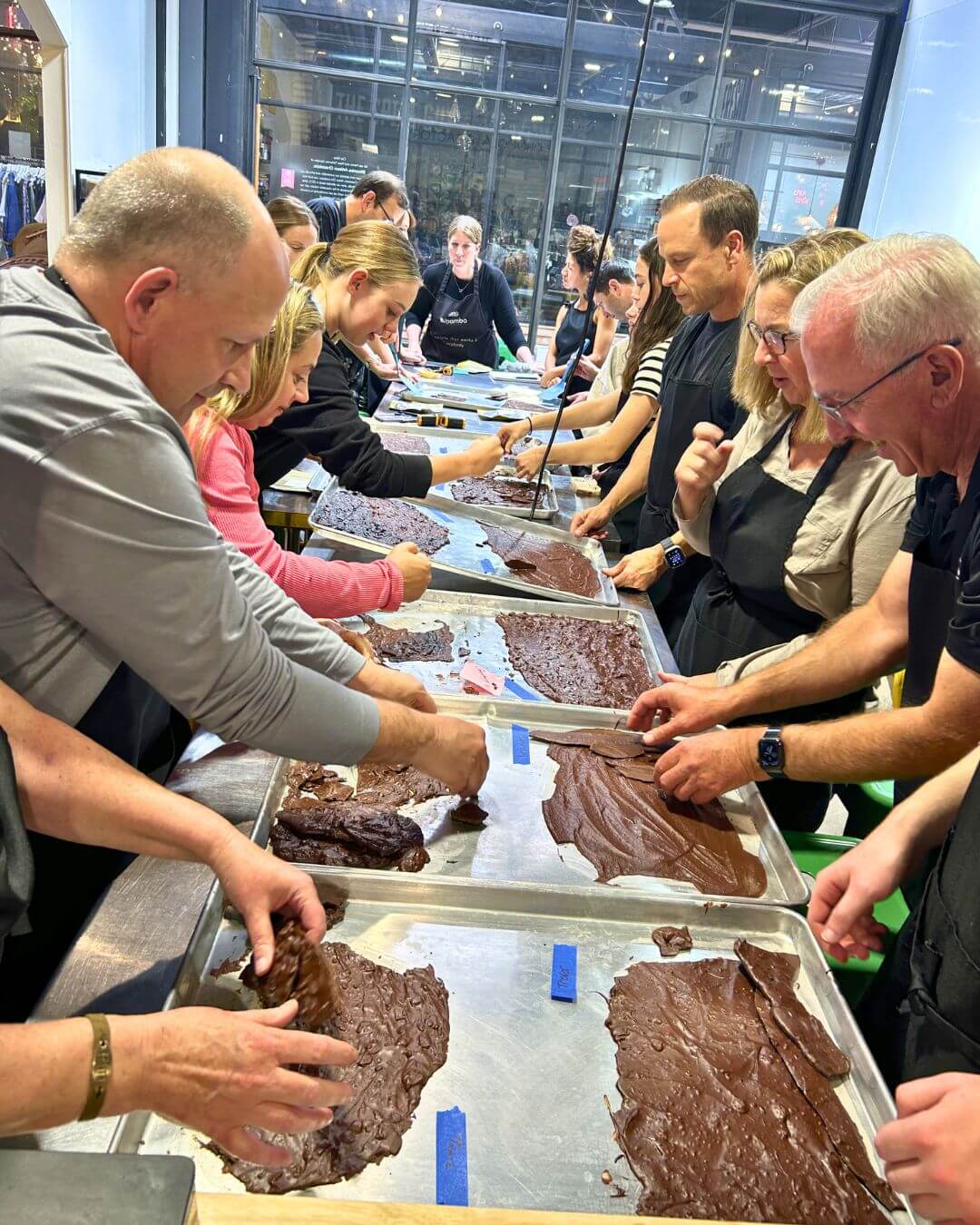 Group of people working with chocolate at a chocolate-making demonstration.